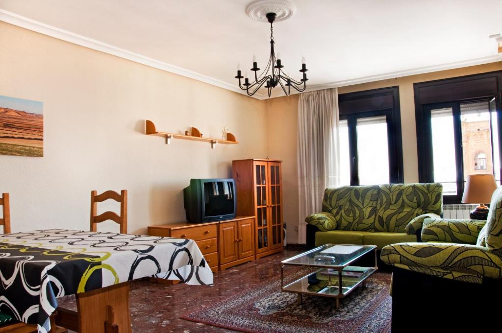 sala de estar con cama, sofá y TV en Palacio Gómara-Bardenas, en Valtierra