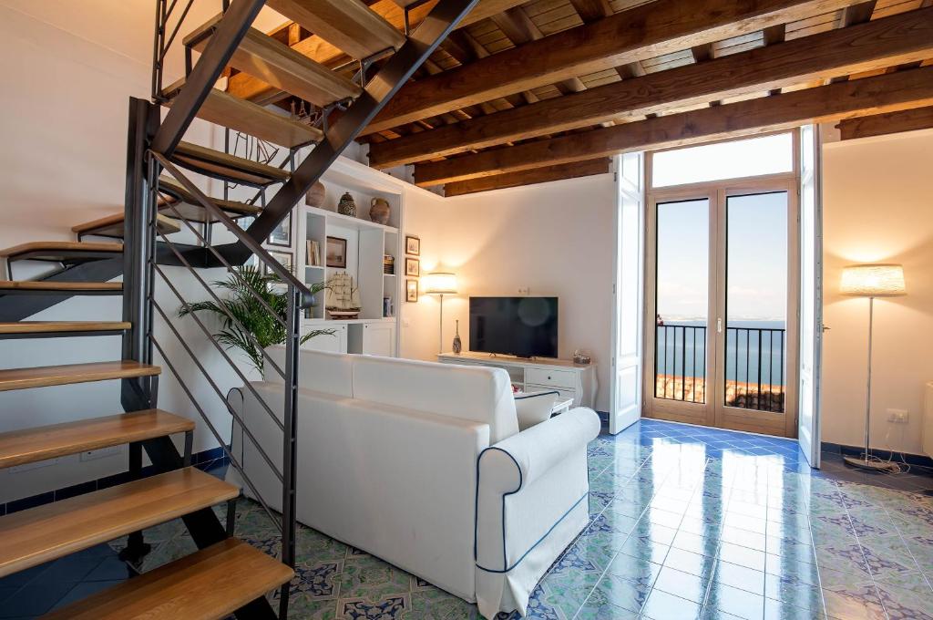 a living room with a white couch and a staircase at Starhost - CASA ADA in Vietri sul Mare