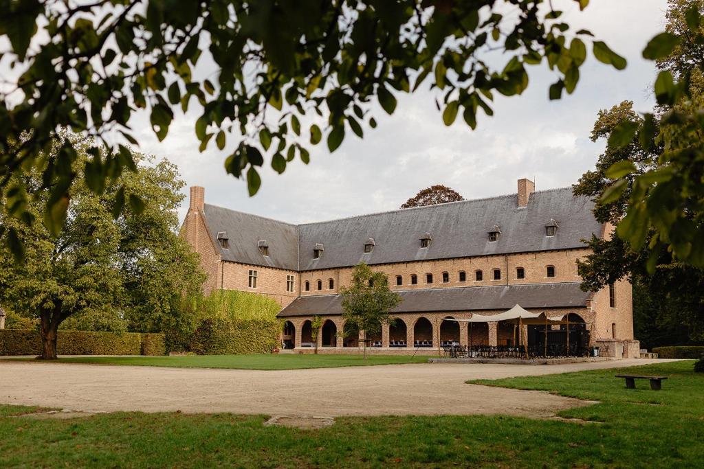 a large brick building with a large roof at Priorij Corsendonk in Oud-Turnhout