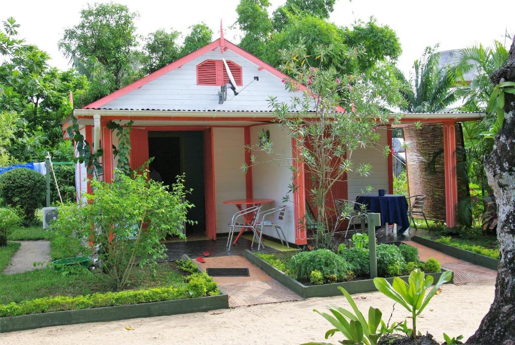 a small red and white house with a garden at Comfortable Studio with Sea View in Foulpointe - 30 m² in Foulpointe