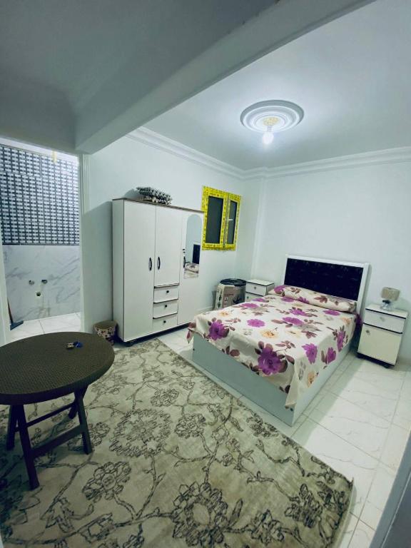 a bedroom with a bed and a table and a chair at بيت سعد in Hihyā