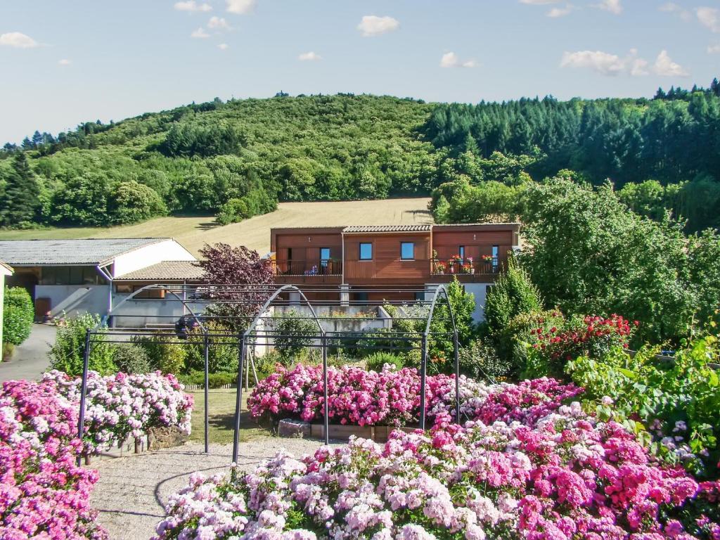 a garden of flowers with a house in the background at Appartement cosy à Fayet avec vue in Fayet