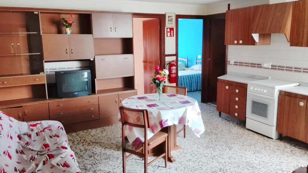 a kitchen with a table with a vase of flowers on it at Spacious apartment with balcony - Guardamar del Segura - 100 m² in Guardamar del Segura