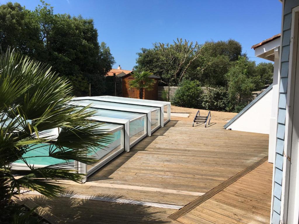 a deck with a bench on top of a house at Villa ensoleillée à Saint Hilaire de Riez avec piscine privée in Saint-Hilaire-de-Riez