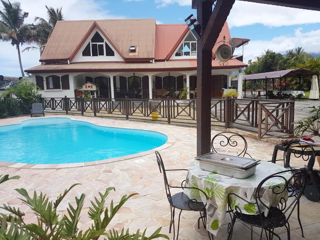 a table and chairs next to a swimming pool at Villa charmante à Saint-Benoît avec piscine privée in Saint-Benoît