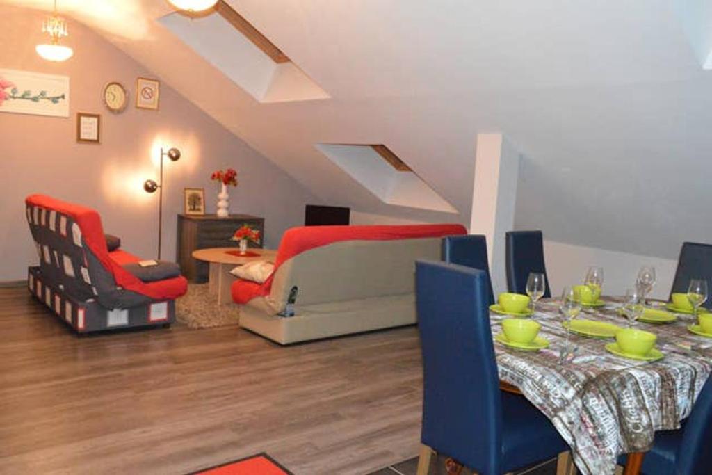 a living room with a table and chairs and a bed at Appartement chaleureux à Gérardmer avec parking privé. in Gérardmer