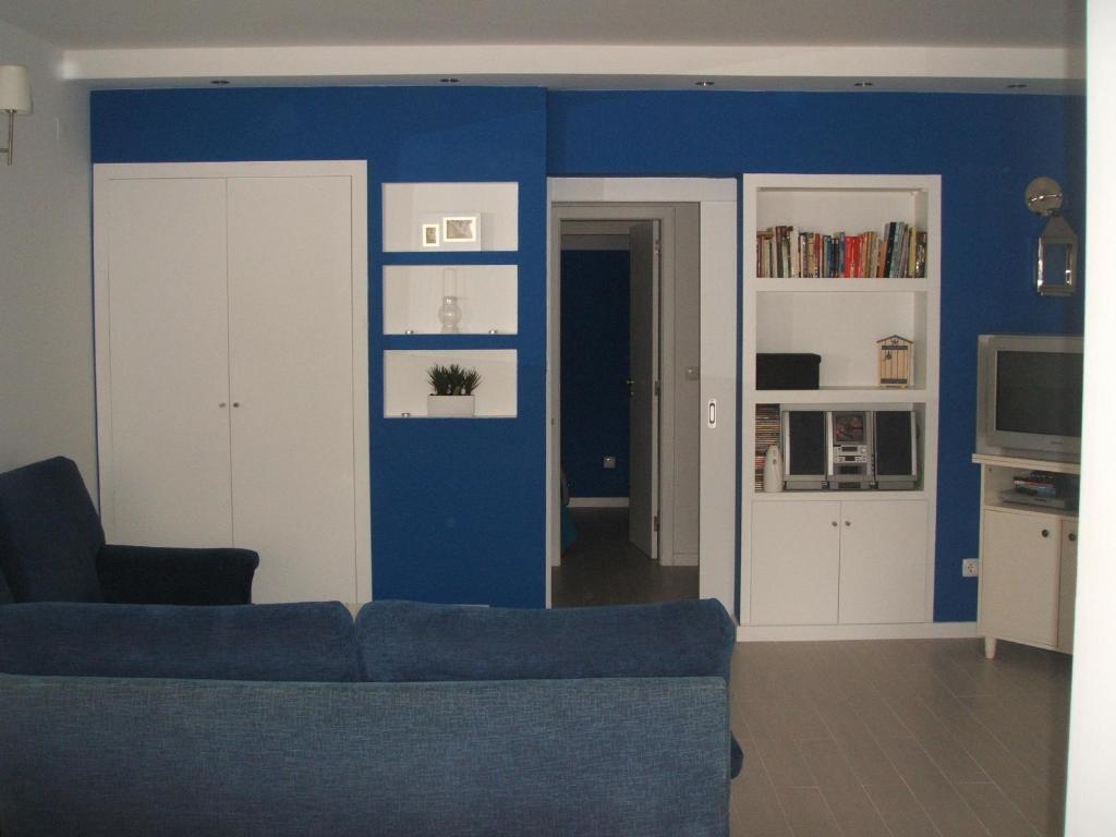 a living room with a couch and a blue wall at Charming Apartment in Troia, Garden View, 60 sqm in Troia