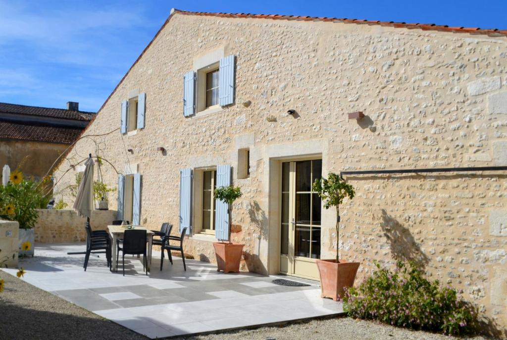 a patio with a table and chairs in front of a brick building at Maison spacieuse à Cabariot in Cabariot