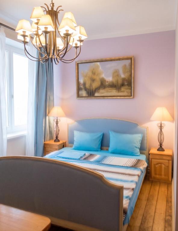 a bedroom with a bed with blue pillows and a chandelier at Spacious House in Central Sofia with Garden in Sofia