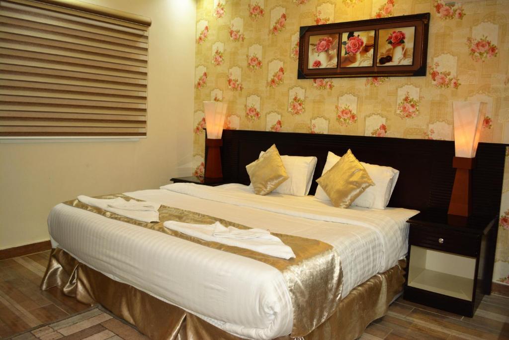 a bedroom with a large bed in a room at Saba Ohod For Hotel Suites in Al Madinah