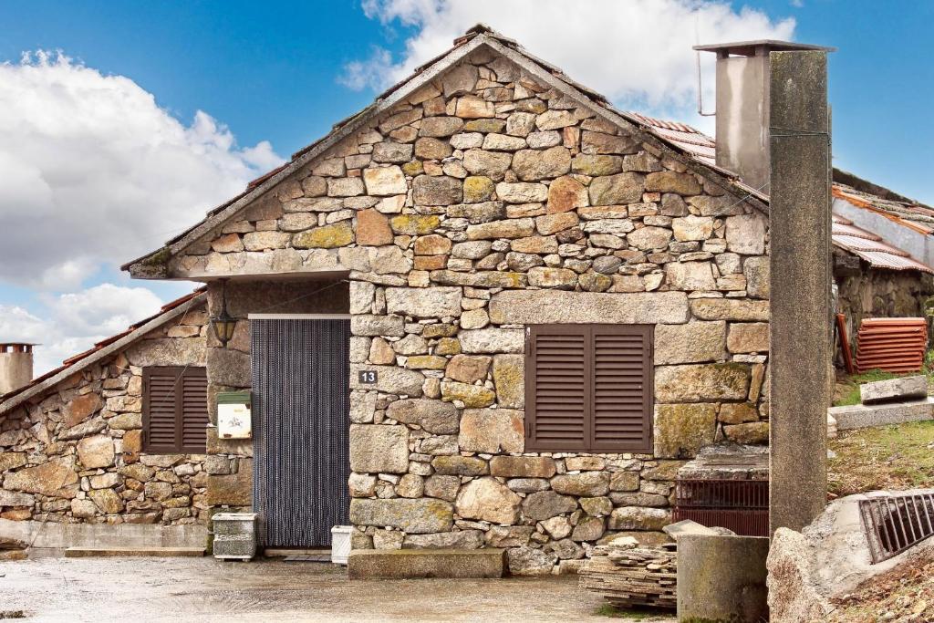 an old stone building with a door at Charming House in Paredes do Rio with Mountain View in Paredes do Rio