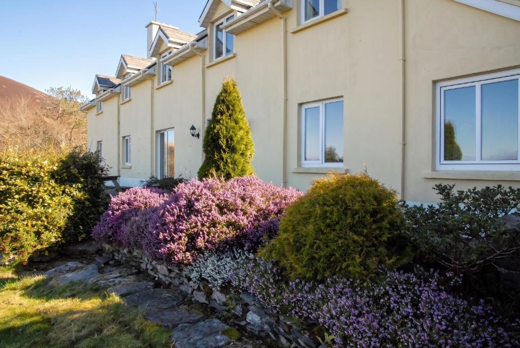 a house with purple flowers in front of it at Spacious house with sea and mountain views, Co. Kerry in Kells