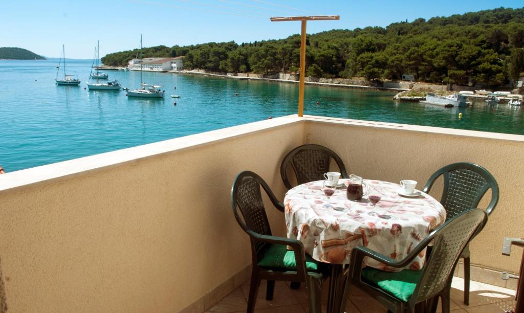 a table on a balcony with a view of the water at Sea View Apartment in Prvić Luka, 46m², Terrace in Prvić Luka