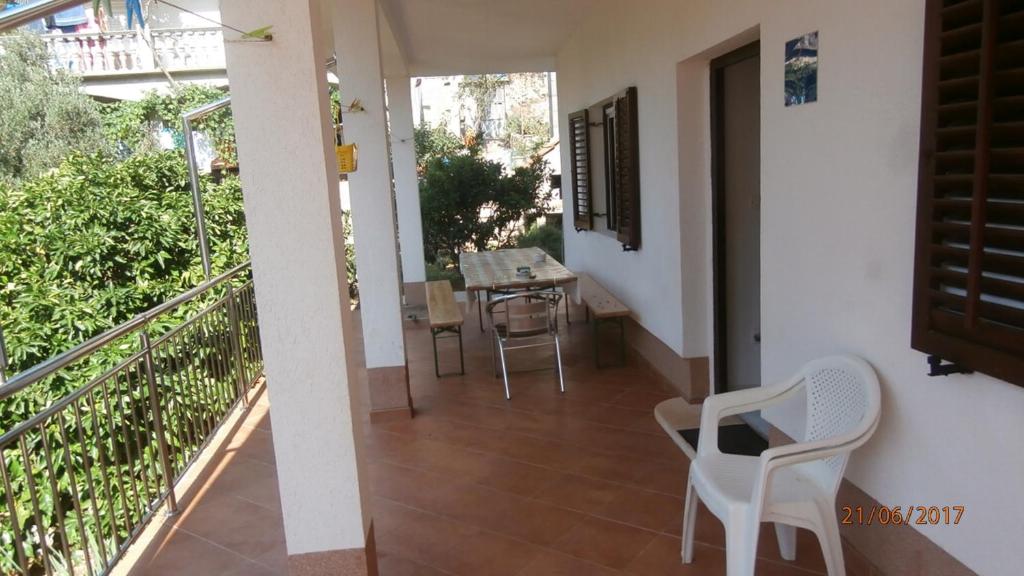 a balcony with white chairs and a table on it at Charming Apartment in Gdinj + Garden in Gdinj