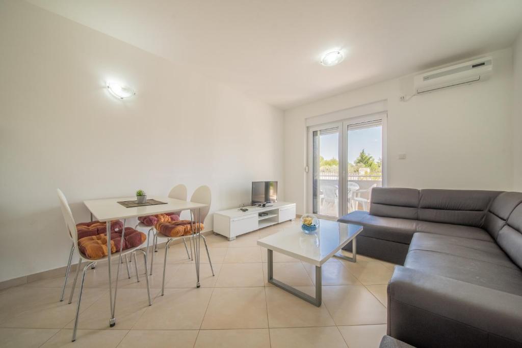 a living room with a couch and a table at Bright Apartment in Vrsi with Terrace and Garden, 65 m² in Vrsi