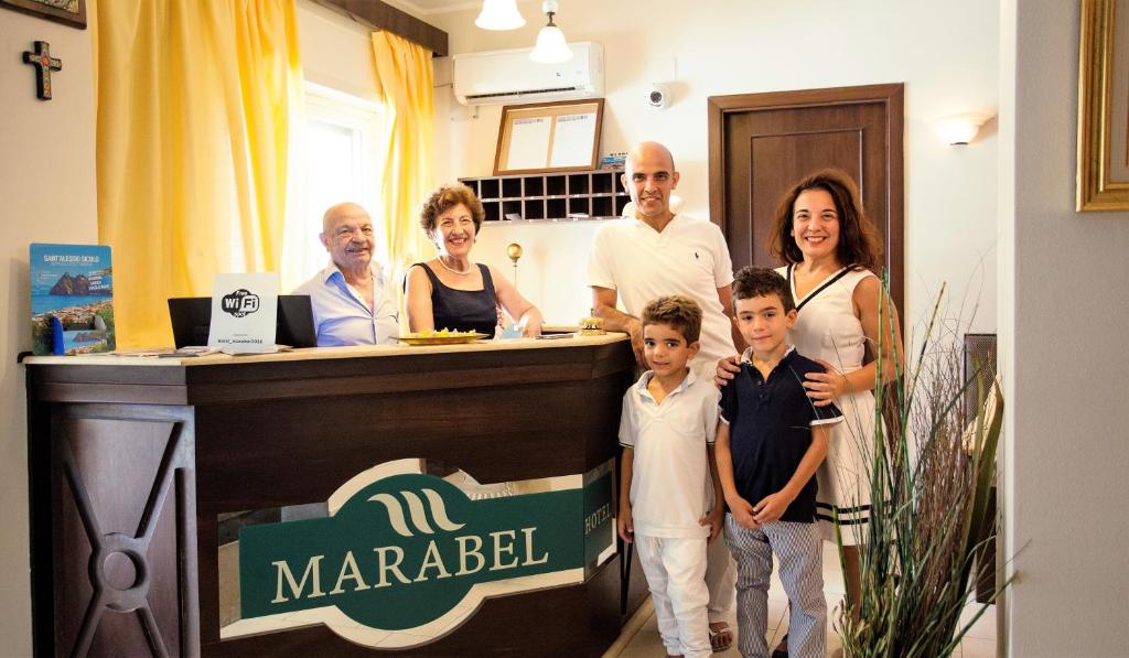 un grupo de personas de pie en frente de un mostrador en Hotel Marabel, en SantʼAlessio Siculo