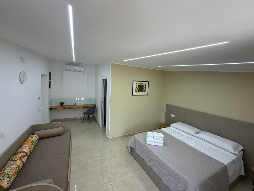 a bedroom with a bed and a couch in it at Luxury Room Home Serpico in Scisciano
