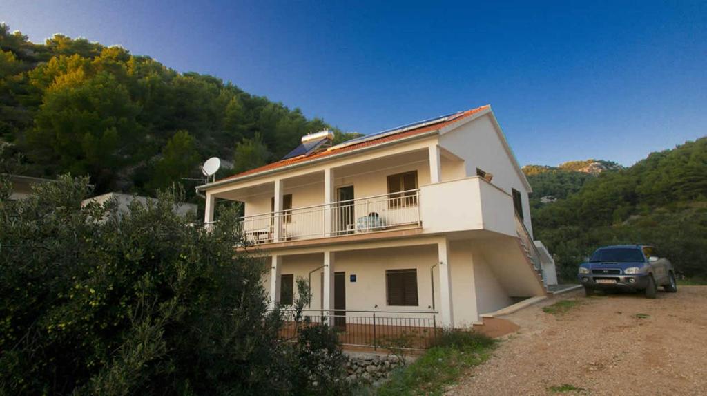 a white house with a truck parked in front of it at Charming Apartment with Sea View, Gdinj, 70 m², Garden in Gdinj