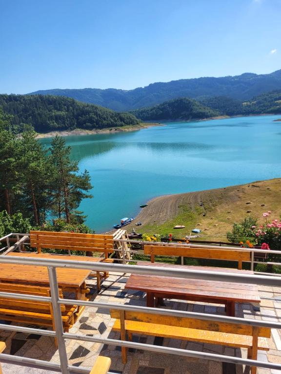 a view of a lake with wooden benches at Vila Arena in Mandići