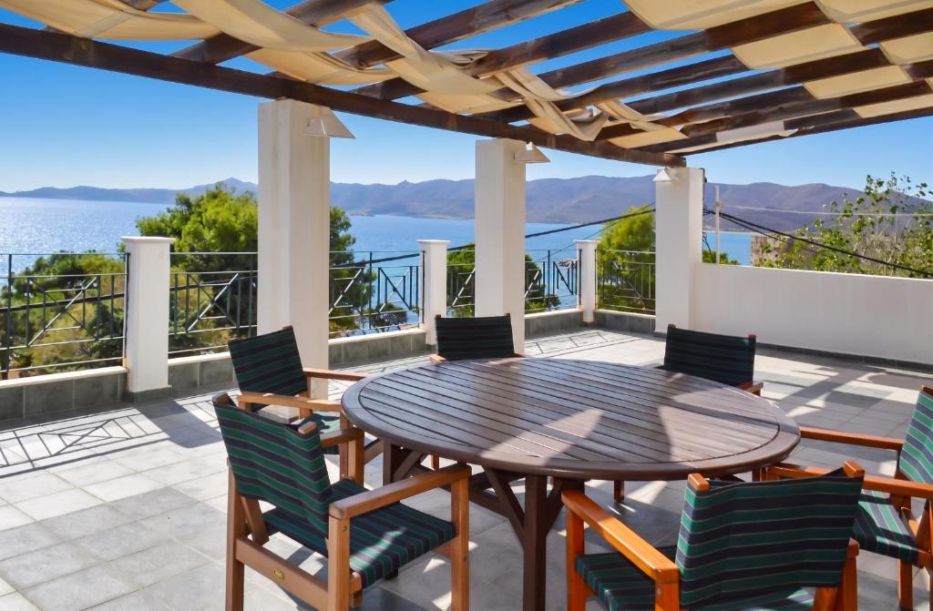 a table and chairs on a patio with a view of the water at Charming Villa with Sea View in Karistos in Karistos