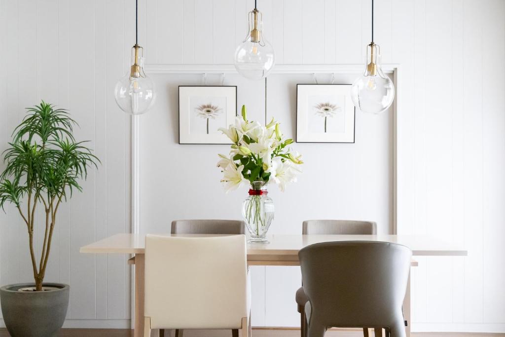 a dining room table with two chairs and a vase of flowers at HABi-Sekido5 in Wakayama