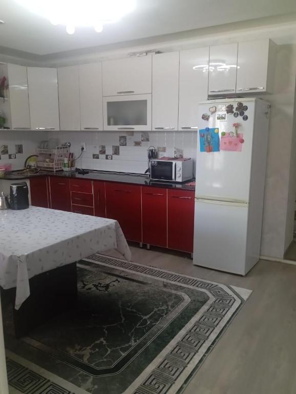 a kitchen with a white refrigerator and red cabinets at Adelina in Kyzart
