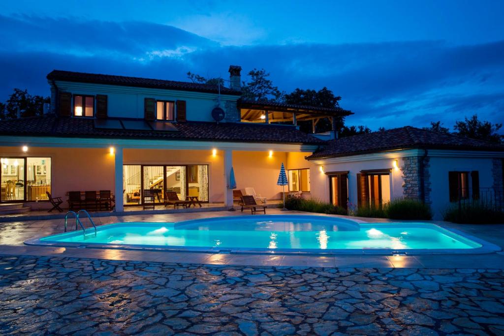 a swimming pool in front of a house at night at Charming Villa near Žminj with Private Pool in Žminj