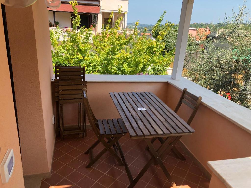 a wooden table and two chairs on a balcony at Cozy house in Chieti with private garden in Chieti