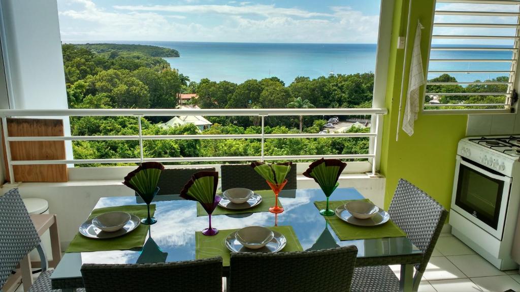 a dining room with a table and a view of the ocean at Appartement moderne à Sainte-Anne 43 m² avec vue mer in Sainte-Anne