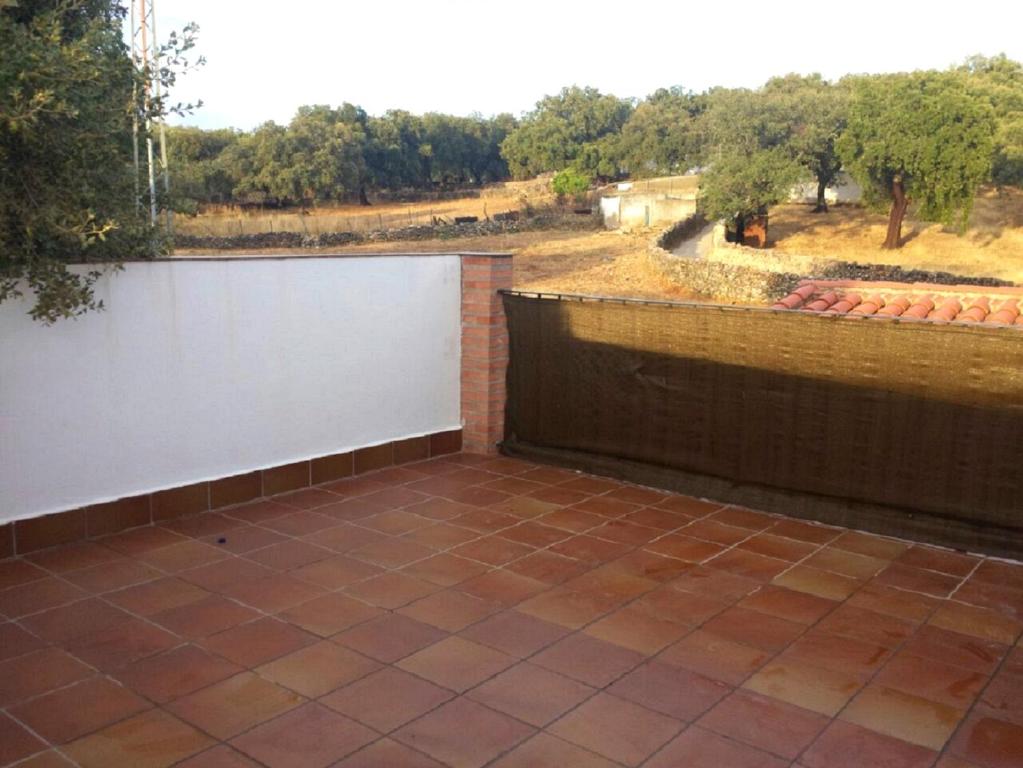 a patio with a white wall and a fence at Charming apartment with mountain view in Jabuguillo, 70 m² in Aracena