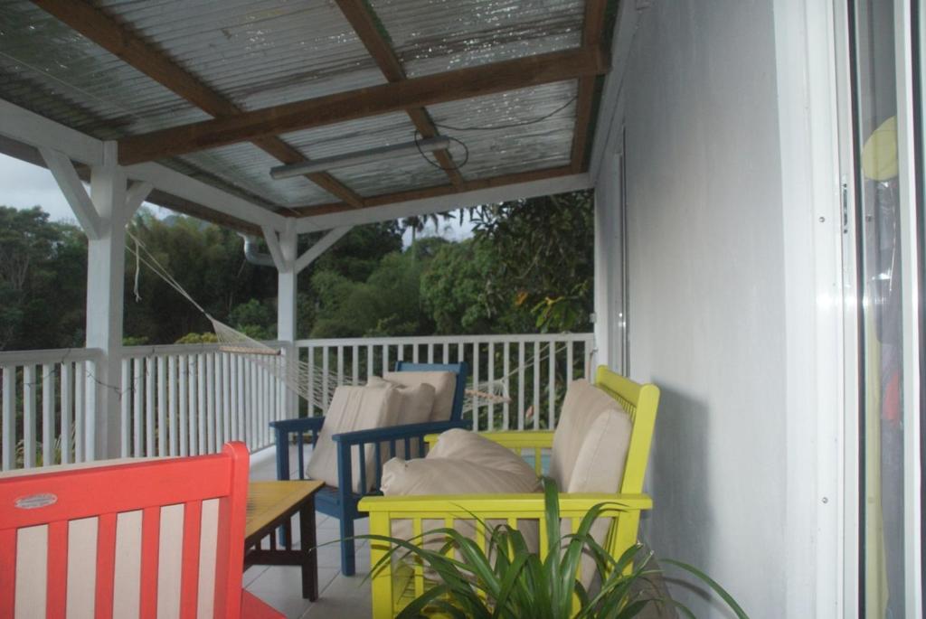 a porch with chairs and a table and awning at Studio avec vue sur la mer à Fort-de-France 50 m² exceptionnel ! in Fort-de-France