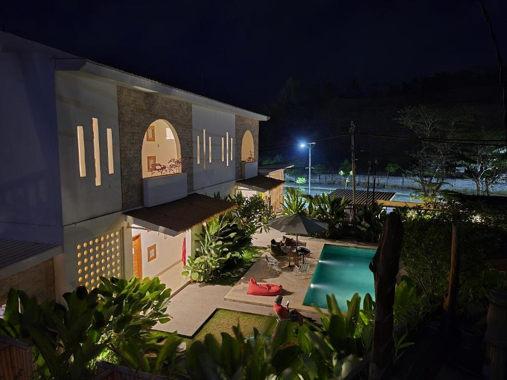 a building with a swimming pool at night at Snuggy Hostel Kuta in Kuta Lombok