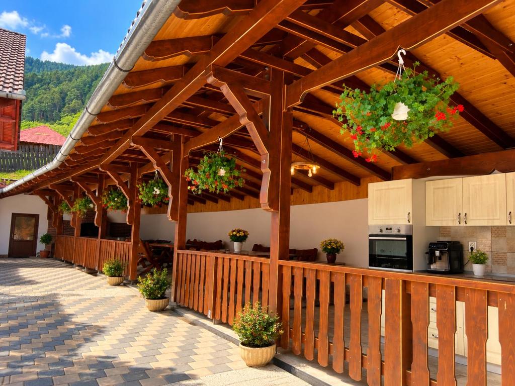 a wooden pavilion with potted plants on a patio at Pensiunea Hanzu Darius in Gura Râului