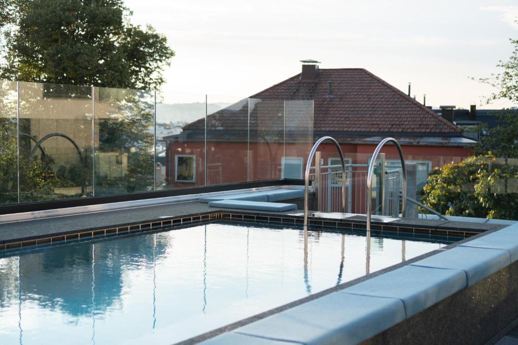 a swimming pool with water in front of a house at Sommerro in Oslo
