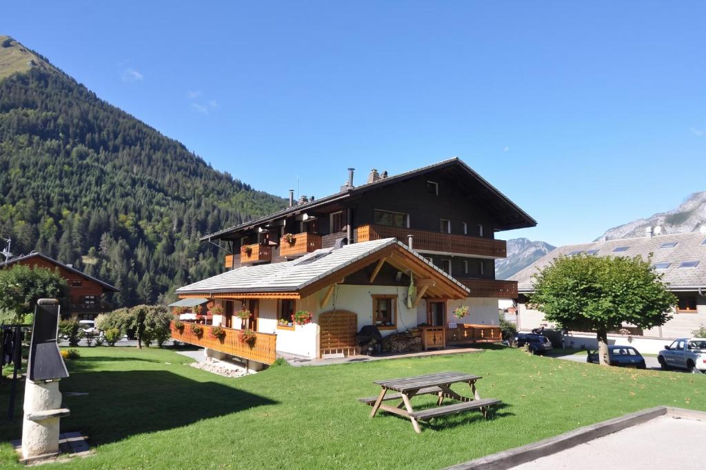 a large building with a picnic table in front of it at Appartement confortable à La Chapelle-d'Abondance 75 m² avec jardin in La Chapelle-dʼAbondance