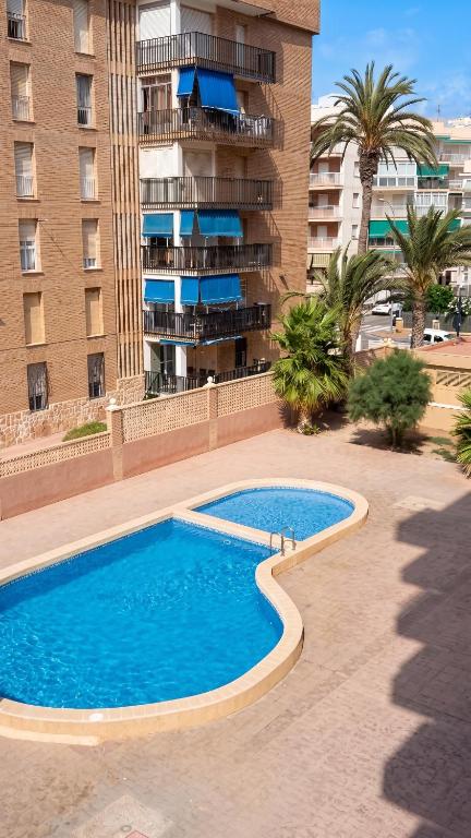 a large swimming pool in front of a building at Apartment with pool in Águilas 75 m² with sea view in Águilas