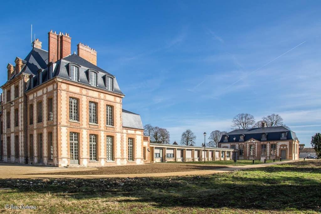 a large brick building with a black roof at Studio charmant à Abondant, 30 m² avec jardin in Abondant