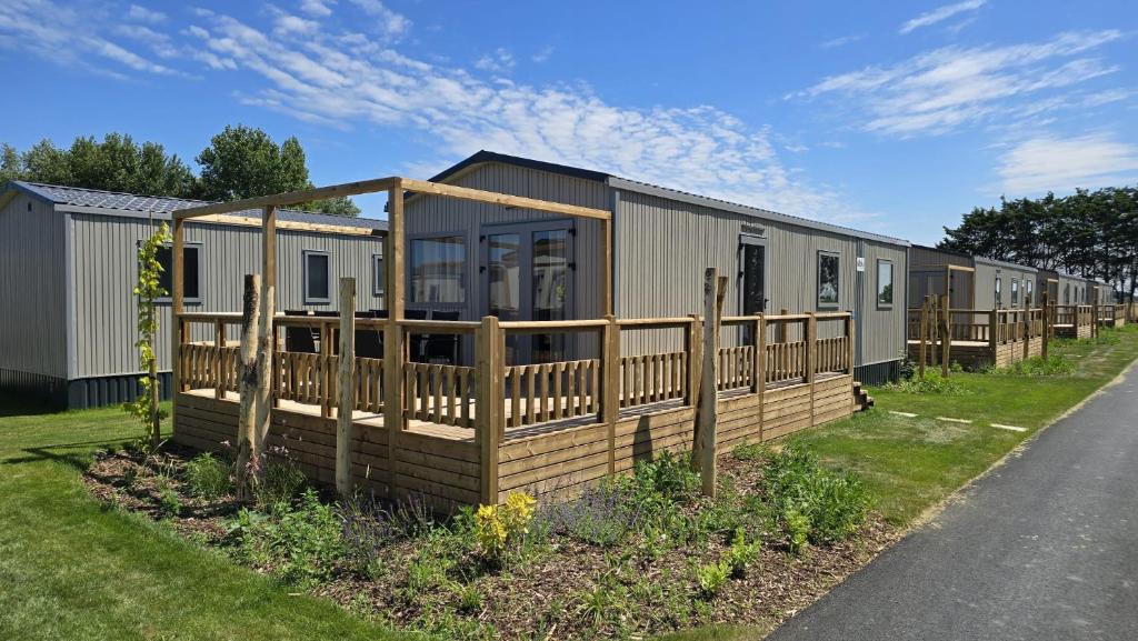 a modular home with a wooden fence next to a road at Beachside Vakantiepark in Blankenberge