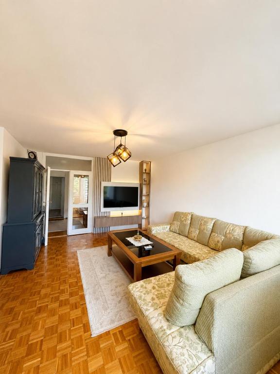a living room with a couch and a table at Riverside Apartment, 10min Airport in Sarajevo