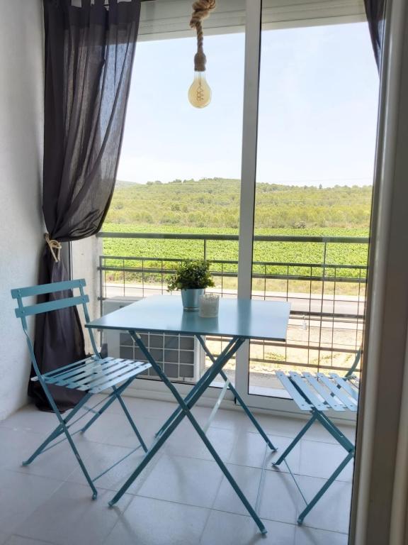 a table and two chairs in front of a window at Charming apartment with mountain view in Francàs - 45m² in Comarruga