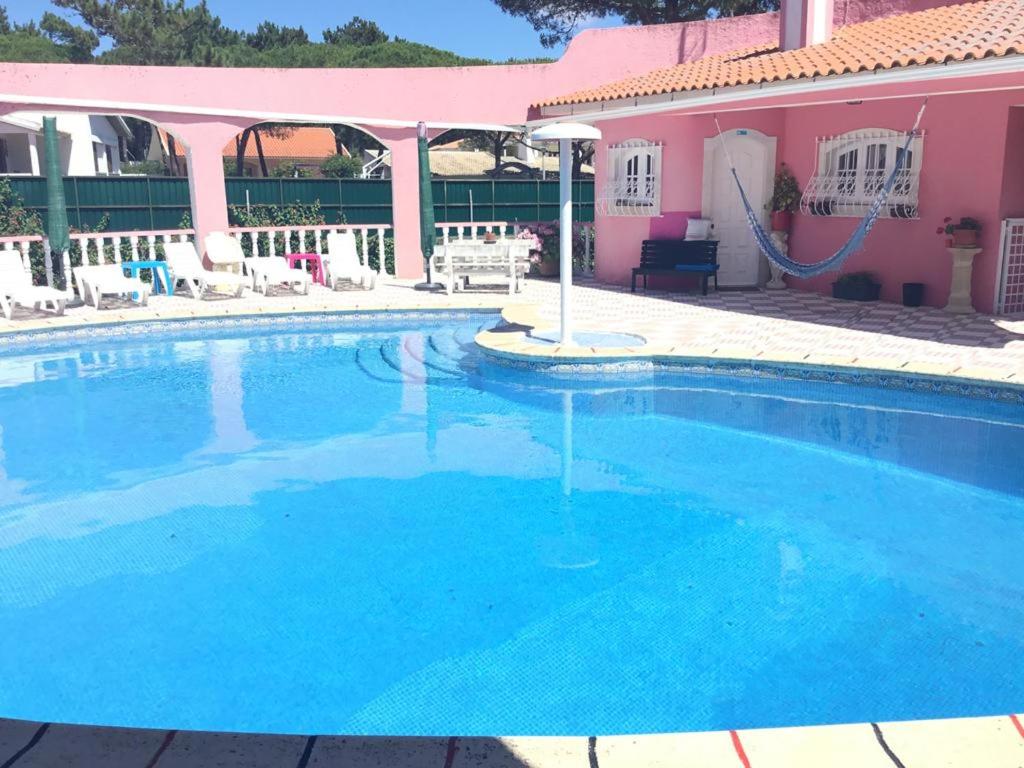 a large swimming pool in front of a pink house at Spacious Apartment Sintra 120 m² + Pool in Sintra