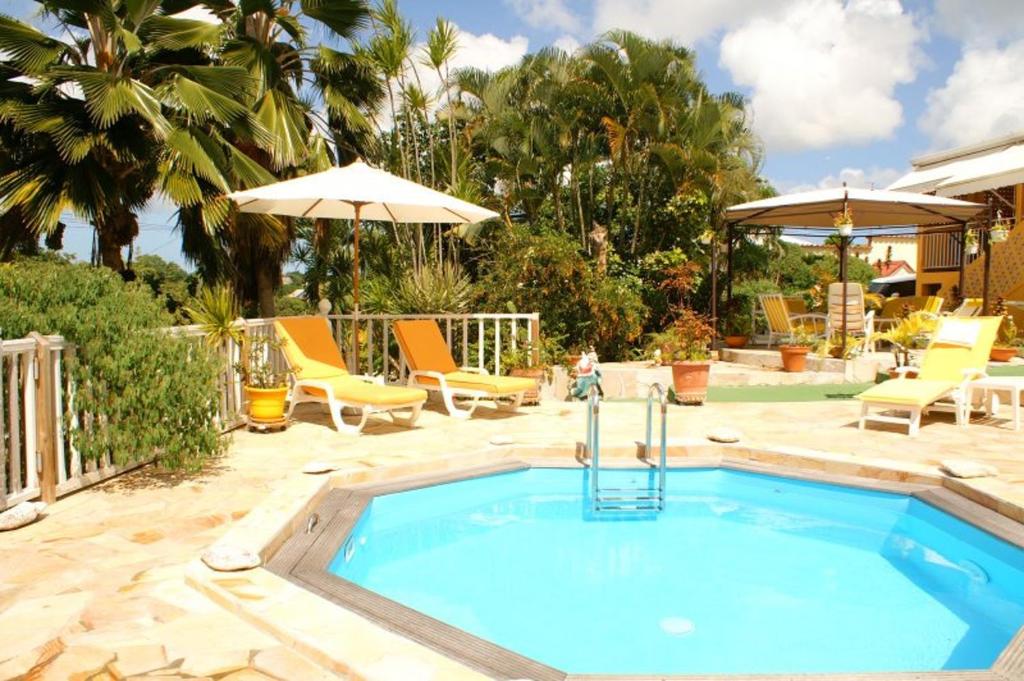 a pool with a hot tub in a yard at Villa élégante à Sainte-Anne avec piscine privée ouverte toute l'année in Sainte-Anne