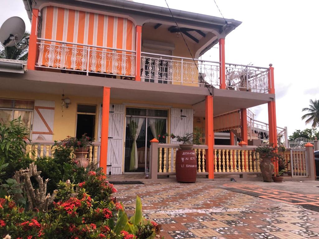 a house with a balcony and a porch at Appartement Moderne à Capesterre de Marie Galante avec Balcon in Vidon