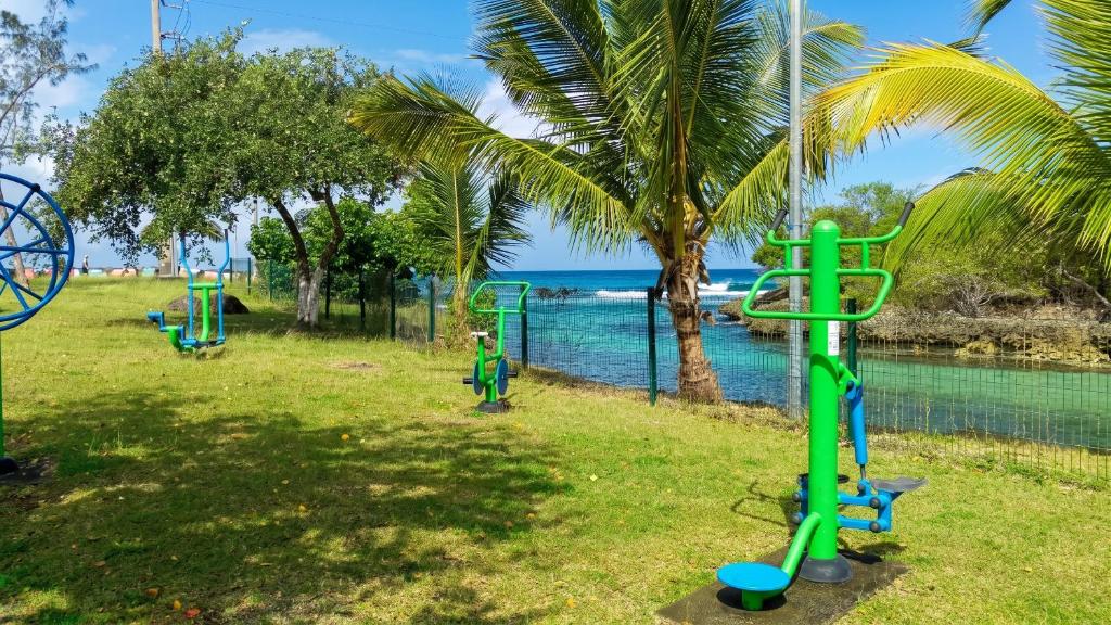 a playground in a park next to a body of water at Maison accueillante à Anse-Bertrand avec jardin privé 70 m² in Anse-Bertrand
