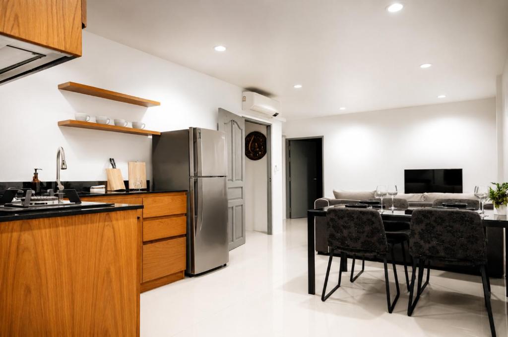 a kitchen with a refrigerator and a table with chairs at The One Apartment in Rawai Beach