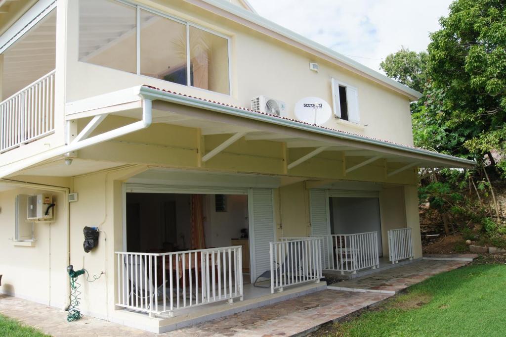 a house with a porch and a balcony at Studio cosy au Moule 30 m² avec jardin privé in Le Moule