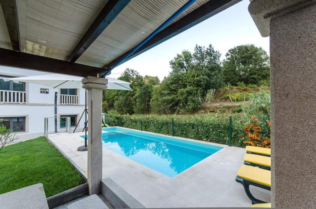 a swimming pool in the backyard of a house at Charming villa in Cividade, 150 m² with private pool in Cividade