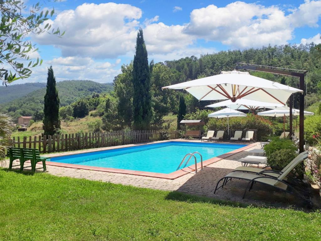 a swimming pool with an umbrella and a table and chairs at Spacious Apartment in Lisciano Niccone with Mountain View in Mercatale