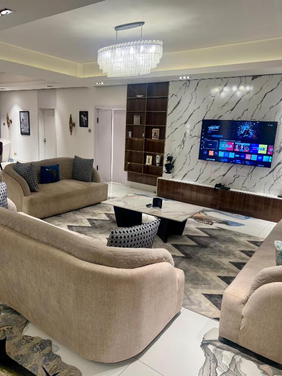 a large living room with couches and a tv at Mac Residence in Lagos