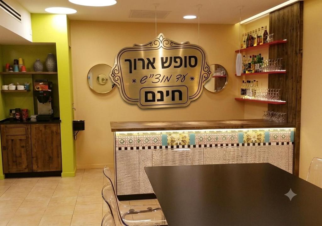 a restaurant with a table and a sign on the wall at Mizpe Yam Boutique Hotel in Netanya
